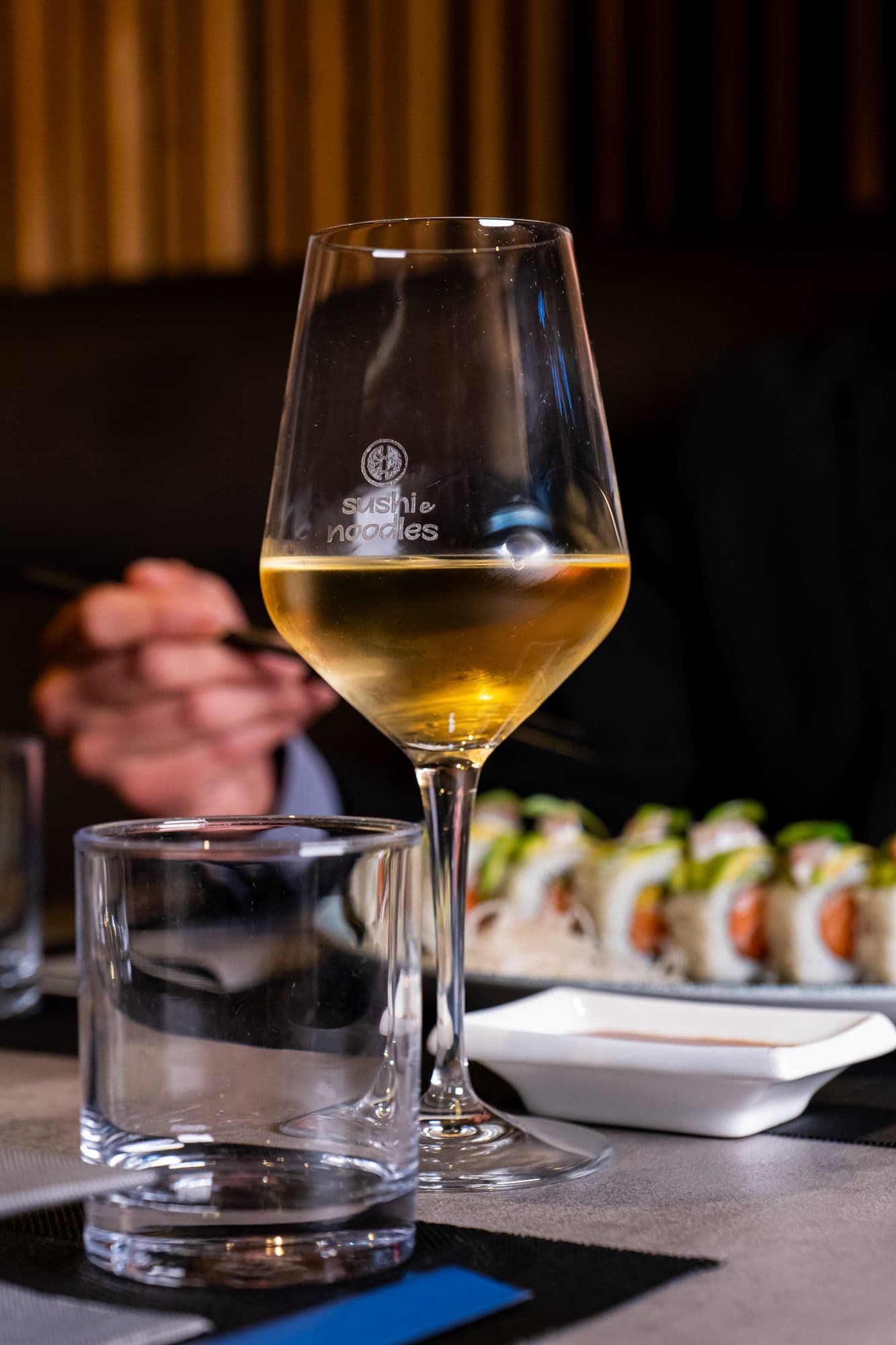 Un calice di vino bianco accanto al sushi