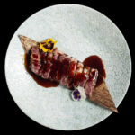 tagliata di carne di manzo nobile giapponese wagyu servita con fiori eduli