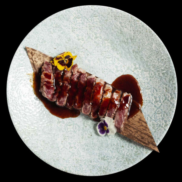 tagliata di carne di manzo nobile giapponese wagyu servita con fiori eduli