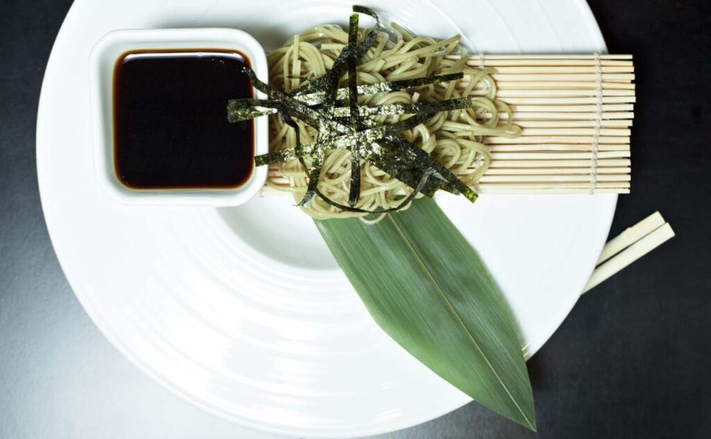 spaghetti di soia su foglia decorativa con alghe e soia