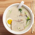 ciotola bianca con ramen in brodo e bacchette