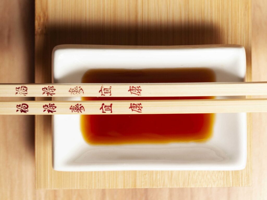 ciotola bianca con salsa per sushi e bacchette giapponesi